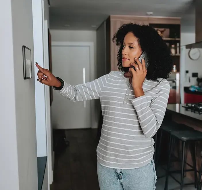 Woman speaking on the phone turning air condition on.